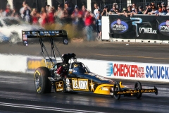 Flames are visible from the US Army Top Fuel dragster of Tony Schumaker.